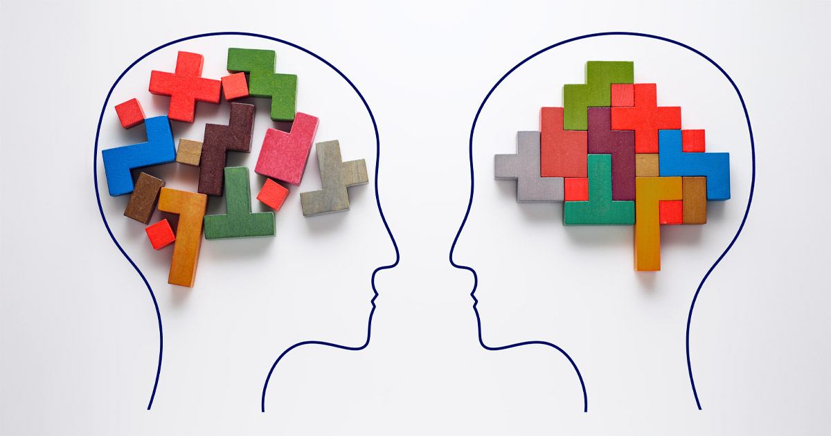 Accessibility design system Outline of two human heads facing each other, each filled with multicolored puzzle pieces symbolizing different ways of thinking or cognitive processing.