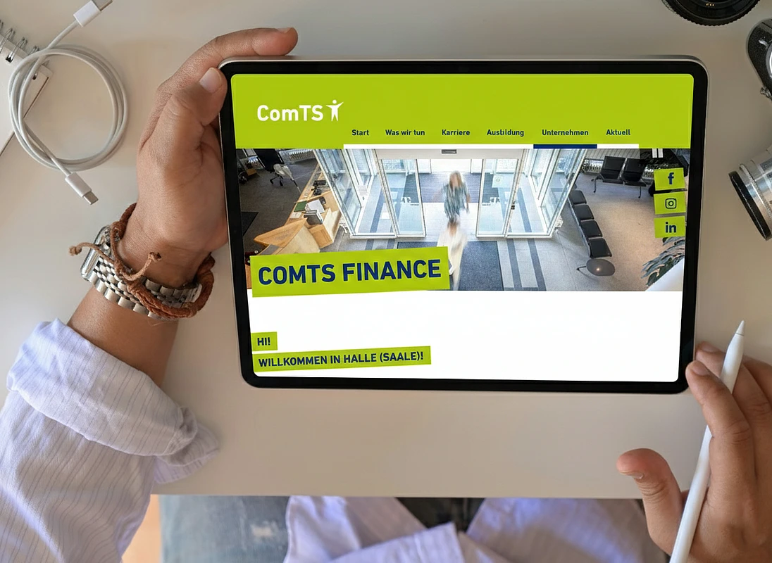A tablet displaying the ComTS Finance website section, highlighting location-specific content and company information.